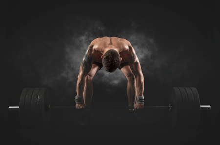 Muscular man workout with barbell at gym. Sports banner. Horizontal copy space backgroundの写真素材