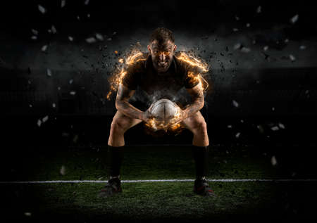 Rugby player in action on dark arenaの写真素材