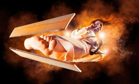 Woman in kimono practicing. Fighter concept. Breaking board. Red smoke backgroundの写真素材