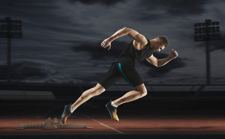 Man sprinter leaving starting blocks on the athletic track