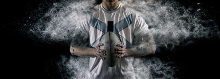 Rugby football player holds ball. Sports banner. Horizontal copy space backgroundの写真素材