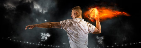 Man rugby player holds ball on fire background. Sports banner. Concept of sport, movement, energy, dynamic, healthy lifestyleの写真素材