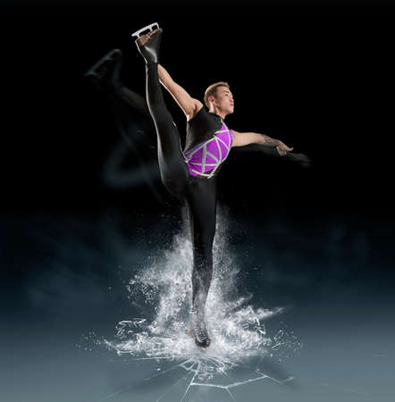 Man figure skating in action on dark backgroundの写真素材