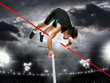 Professional pole vaulter training at the stadium at night. Sports banner. Copy space backgroundの写真素材