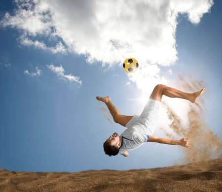 The man footballers are desperately playing beach soccer on sand on a sunny day. Man doing kick on beach with soccer ballの写真素材