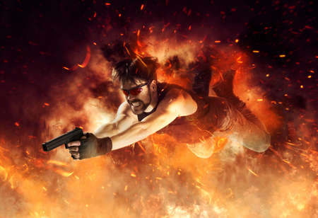 Excited man holding gun on fire background. Movie concept. Mixed mediaの写真素材