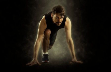 Man sprinter leaving starting on black background. Soft focus effectの写真素材
