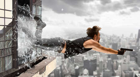 Excited man holding gun. Movie concept. Mixed mediaの写真素材