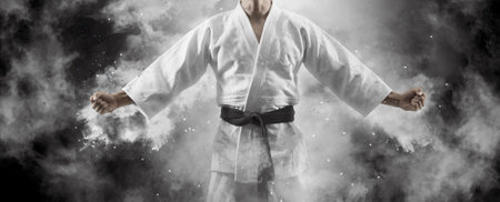 Man in kimono with black belt on smoke backgroundの写真素材