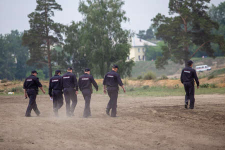 several police officers walk on the sandの写真素材