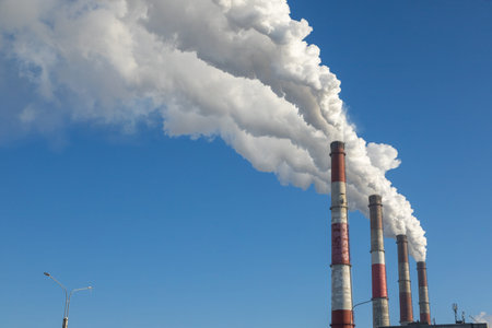 The chimneys of thermal power plants spew smoke into the air against the blue winter sky. CHPP-10 is...
