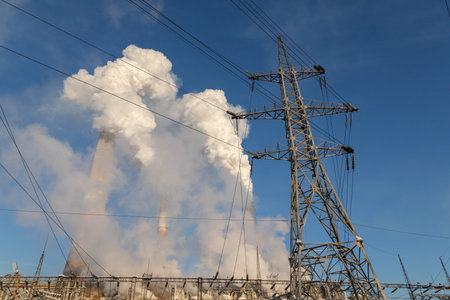 The chimneys of thermal power plants spew smoke into the air against the blue winter sky. CHPP-9 is...