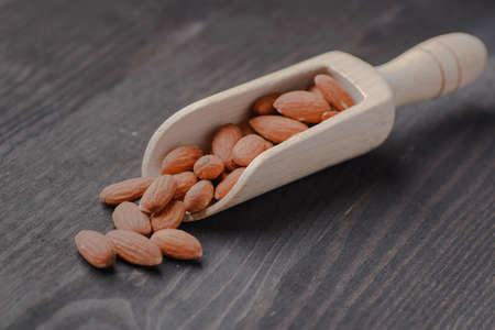 nuts almonds on scales and wooden backgroundの写真素材