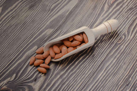 nuts almonds on scales and wooden backgroundの写真素材
