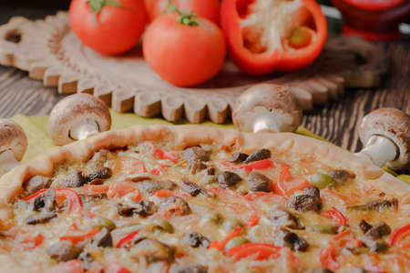 Pizza with mushrooms and with homemade cheese on a wooden tableの写真素材