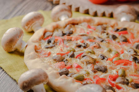 Pizza with mushrooms and with homemade cheese on a wooden tableの写真素材