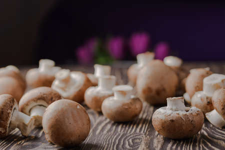 mushrooms champignons on a wooden backgroundの写真素材
