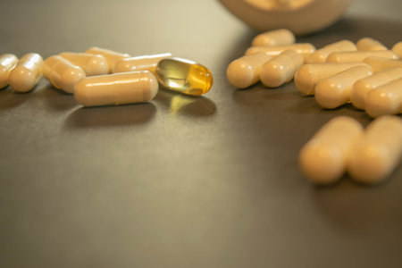 Gelatin capsules with the drug scattered from the bottle on the table.