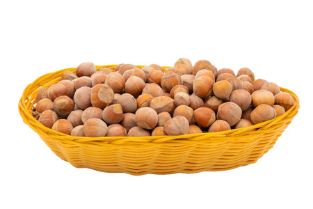 Hazelnuts in a wicker basket. Isolate on white background.の写真素材