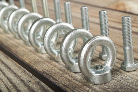 ring nuts with bolts, zinc plated on wooden background.の写真素材