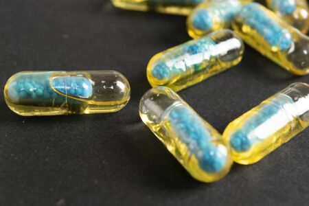 Gelatin capsules with the drug scattered from the bottle on the table.の写真素材