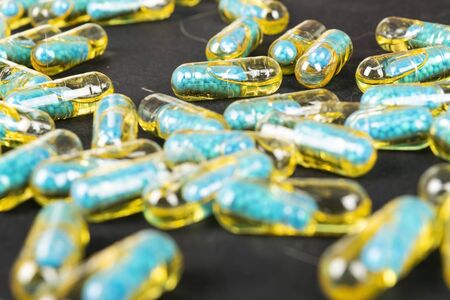 Gelatin capsules with the drug scattered from the bottle on the table.の写真素材