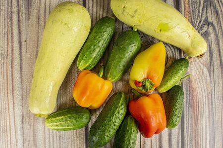 Fresh cucumbers, courgettes and sweet peppers on a wooden table. Autumn harvest thanksgiving Dayの写真素材