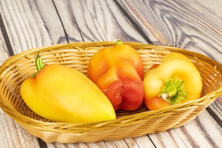 Sweet pepper in a wicker basket on a wooden table. Autumn harvest thanksgiving Day.の写真素材