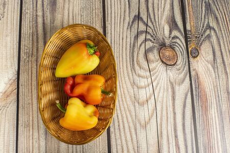Sweet pepper in a wicker basket on a wooden table. Autumn harvest thanksgiving Day.の写真素材