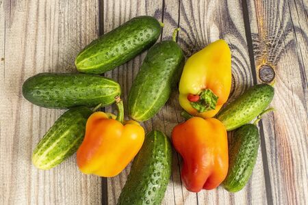 Fresh cucumbers and sweet peppers on a wooden table. Autumn harvest thanksgiving Dayの写真素材