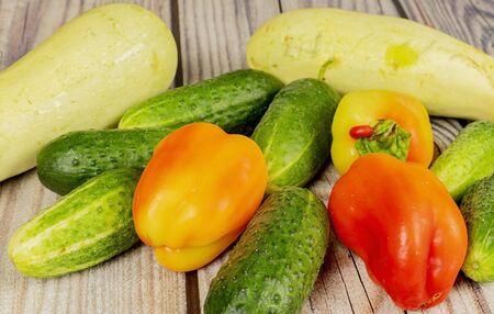 Fresh cucumbers, courgettes and sweet peppers on a wooden table. Autumn harvest thanksgiving Dayの写真素材