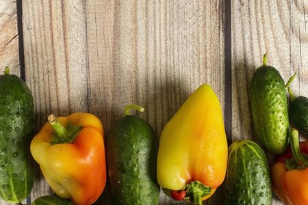 Fresh cucumbers and sweet peppers on a wooden table. Autumn harvest thanksgiving Dayの写真素材