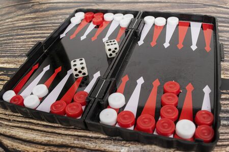 Small pocket backgammon on a wooden table.の写真素材