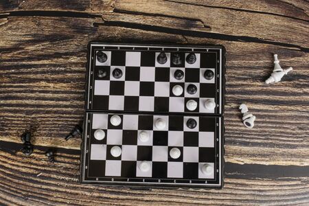 Small pocket chess on a wooden table.の写真素材