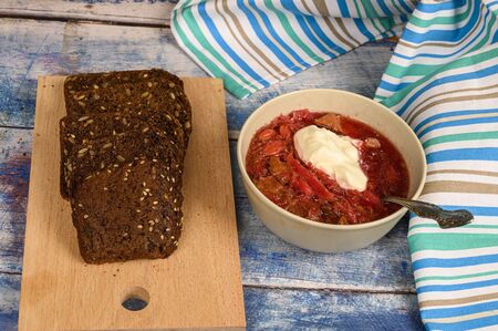 The soup in the plate on the table. Sliced grain bread. Lunch in rustic styleの写真素材