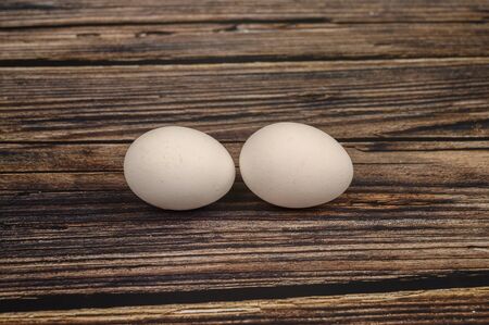 Chicken egg on wooden table background. close up.の写真素材