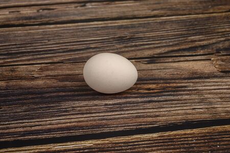 Chicken egg on wooden table background. close up.の写真素材