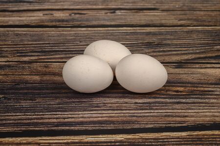Chicken egg on wooden table background. close up.の写真素材