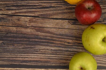 Ripe green and red apples on a wooden table background.の写真素材