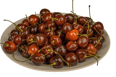 Cherries in a plate on the table. Isolate on white backgroundの写真素材