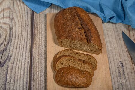 Fresh craft bread on a wooden chopping Boardの写真素材
