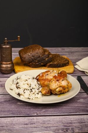 Chicken legs with spices fried in a cauldron, Served on a plate with rice.の写真素材