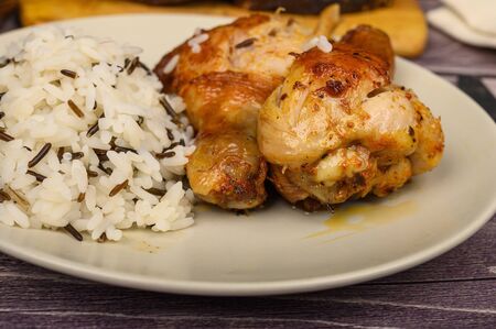 Chicken legs with spices fried in a cauldron, Served on a plate with rice.の写真素材
