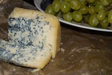 Gorgonzola cheese with blue mold and green grapes. Rustic dinner in vintage style.