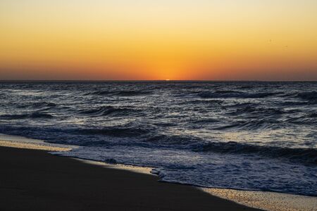 Sunrise over the Black sea, waves on the sandy beachの写真素材