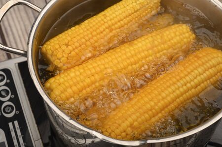 A few ears of corn are cooked in a saucepan. Healthy diet. Fitness diet. For a sweet treat. Close upの写真素材