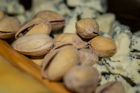 Salt-fried pistachios, Gorgonzola and smoked cheese. Close up.