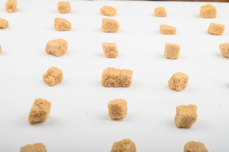 Pieces of brown sugar on a white background