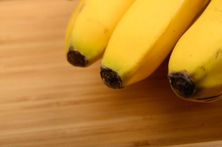 Bunch of ripe yellow bananas on a wooden background. Close upの写真素材