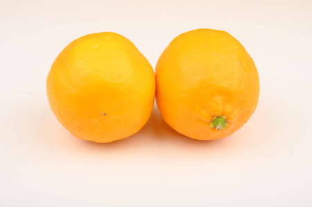 Two ripe yellow lemons on a white background. Close up